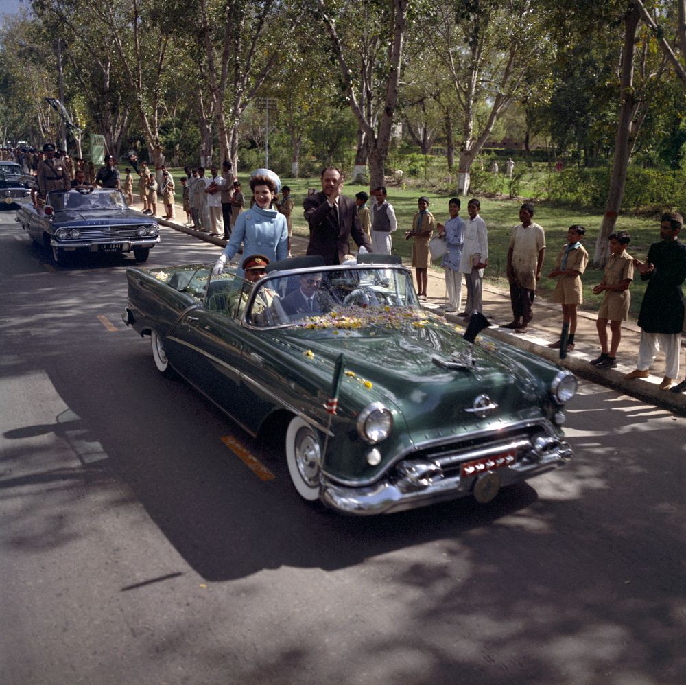 First Lady Jacqueline Kennedy and President of Pakistan, Mohammad Ayub Khan, travel by car to the residence of the Governor of West Pakistan, Malik Amir Mohammad Khan, following Mrs. Kennedy’s arrival in Lahore, Punjab, Pakistan. Secret Service agent, James Jeffries, sits in middle of front seat of car.